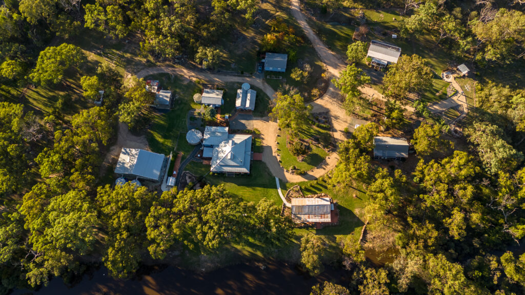 Cottage precinct aerial view, shows bushland surrounds and location of all buildings including 4 cottages